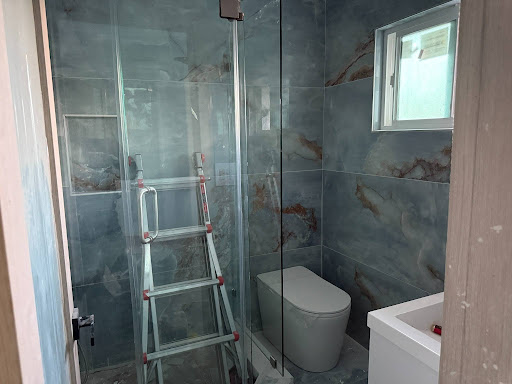 Bathroom remodel with marbled blue tile and glass shower enclosure